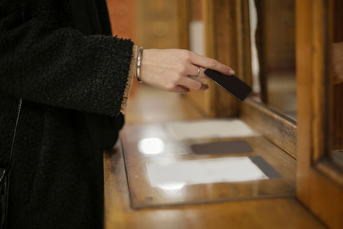 Femme écrivant sur un document avec un stylo à la main, dans un bureau en bois Femme écrivant sur un document avec un stylo à la main, dans un bureau en bois