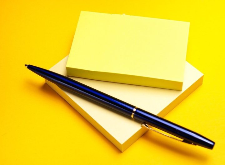 Carnet et stylo bleu sur fond jaune