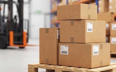 Des cartons empilés sur un palette en entrepôt avec une fourchette