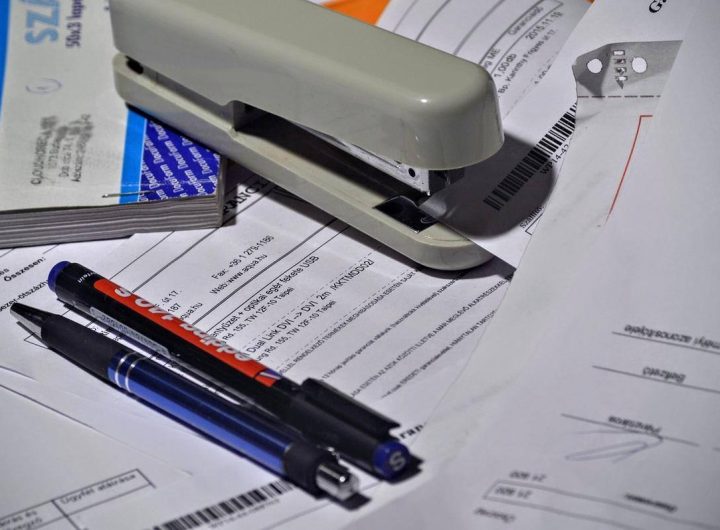 Stylos sur documents avec agrafeuse et classeur sur bureau