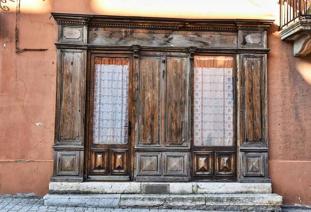 Portes en bois anciennes avec vitrines vitrées sur façade orangée
