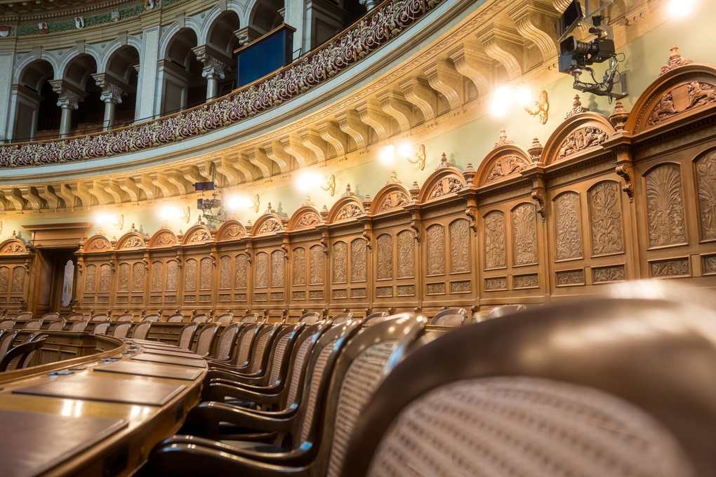 Salle de réunion avec balcons, murs en bois, chaises et tables en bois, lumière ambiante Salle de réunion avec balcons, murs en bois, chaises et tables en bois, lumière ambiante