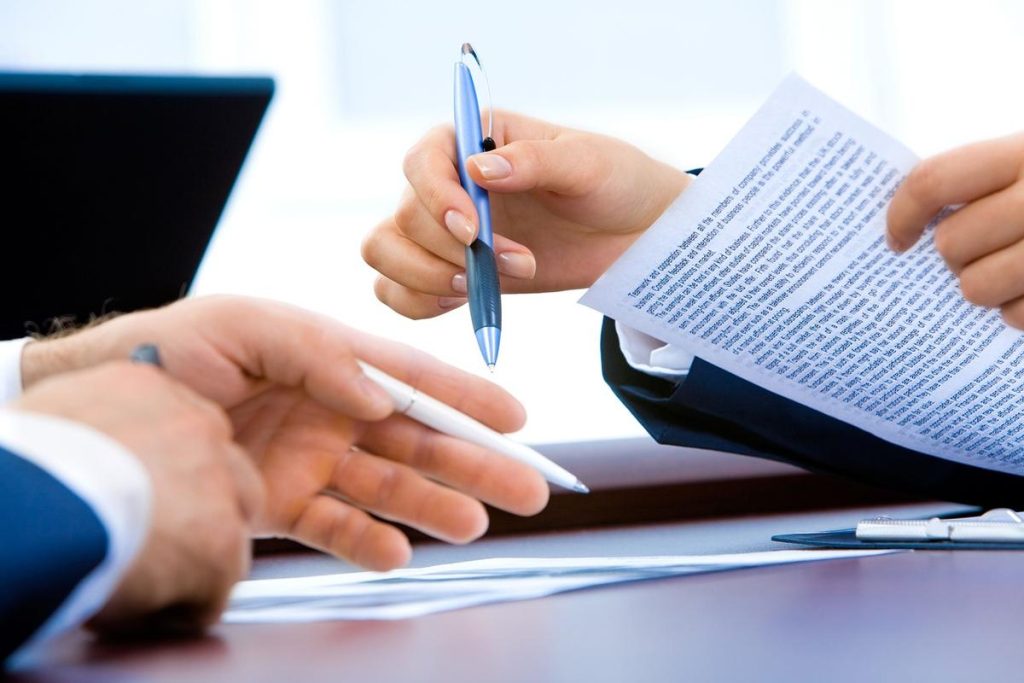 mains tenant stylo et papier sur table de bureau