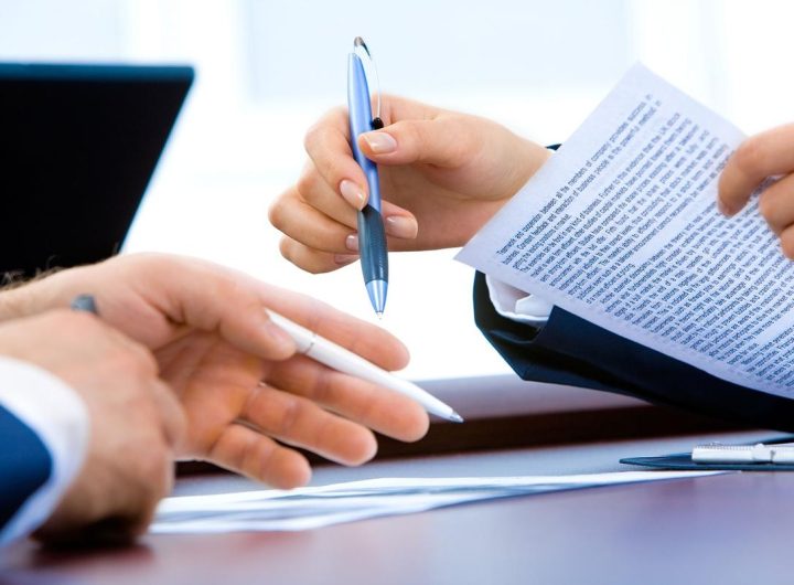 mains tenant stylo et papier sur table de bureau